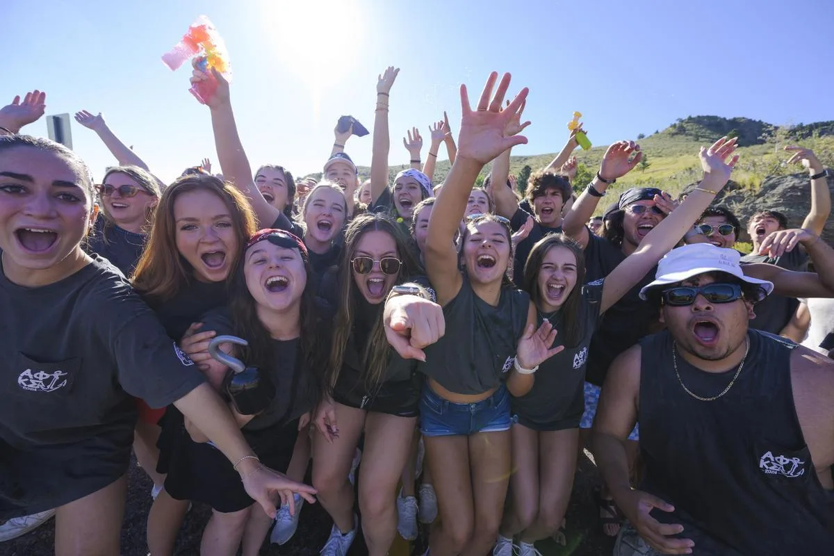 A group of first-year Mines students celebrate completing the M Climb as part of the annual Helluva Welcome program.