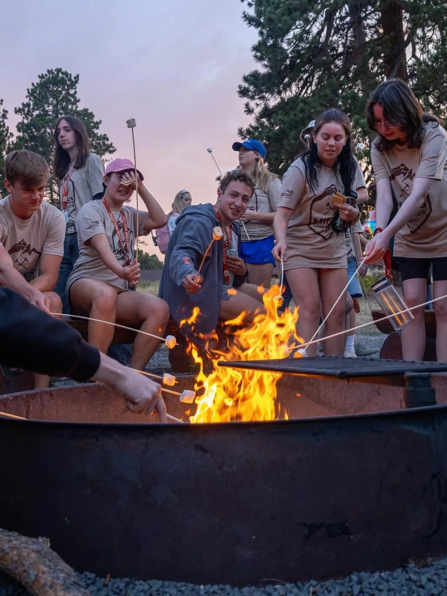 Mines students roast marshmallows over a campfire at Oredigger Camp as part of new student orientation.