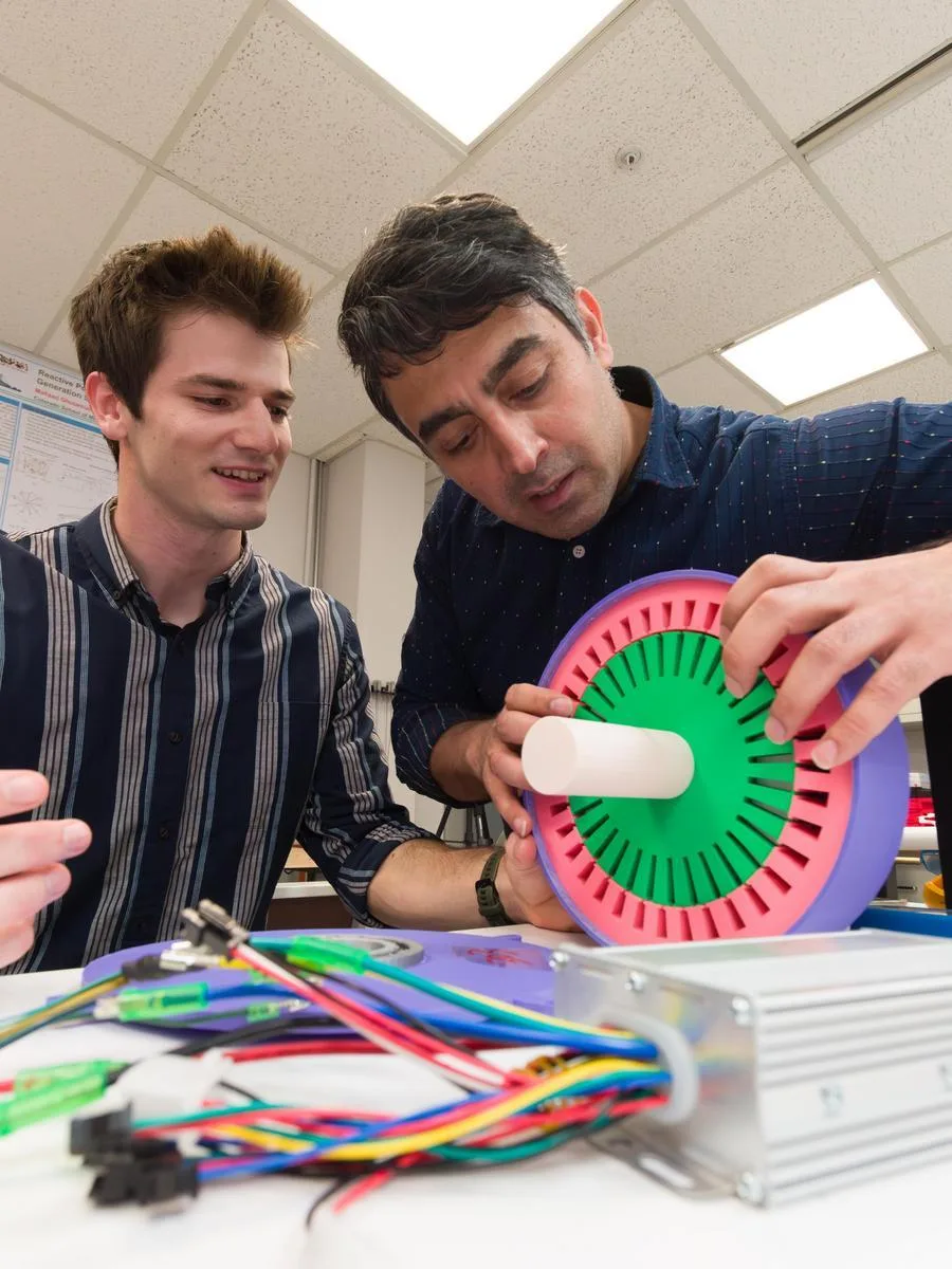 A student works with a professor on an electrical engineering project