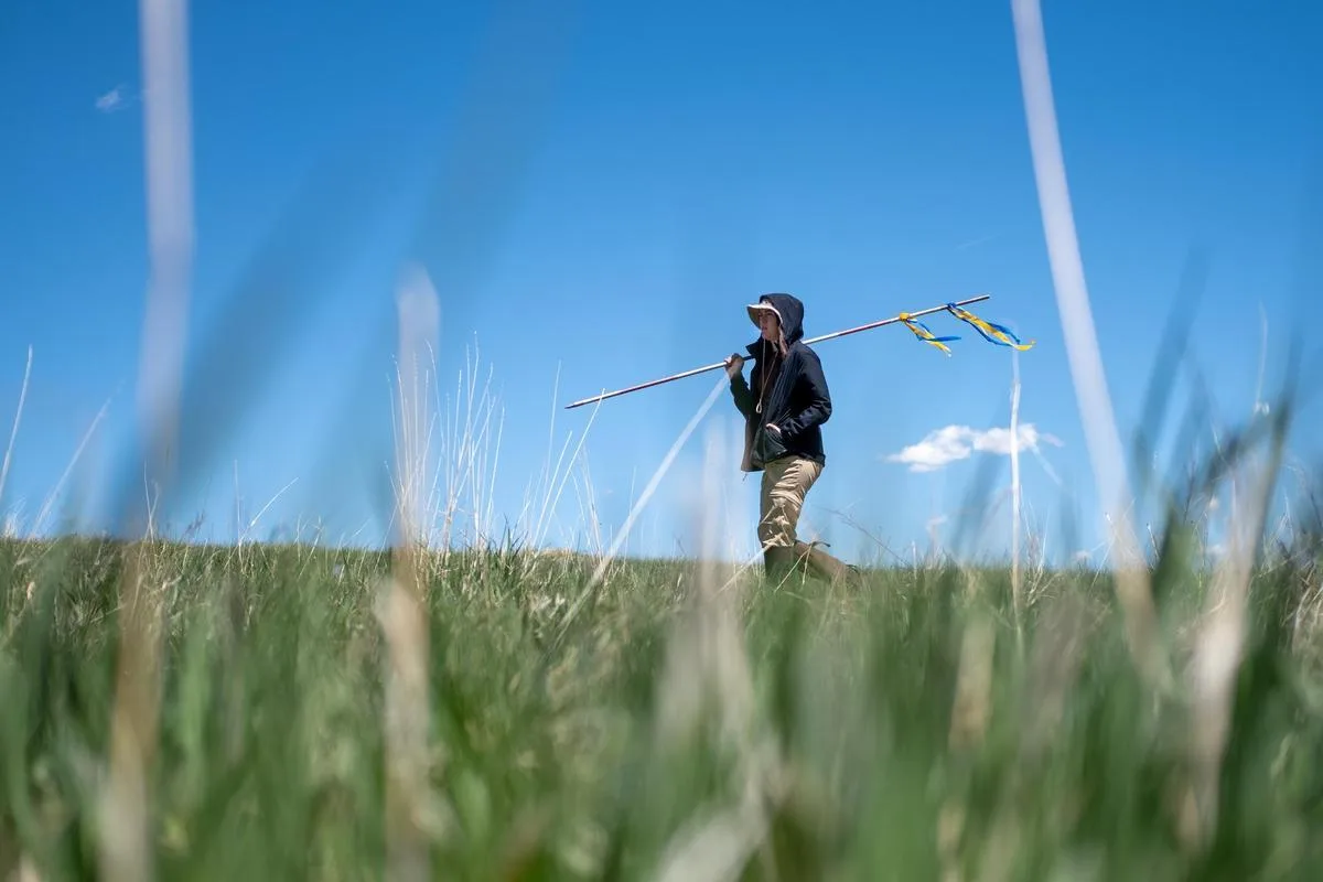 Mines student walking through open field with equipment for monitoring environmental data