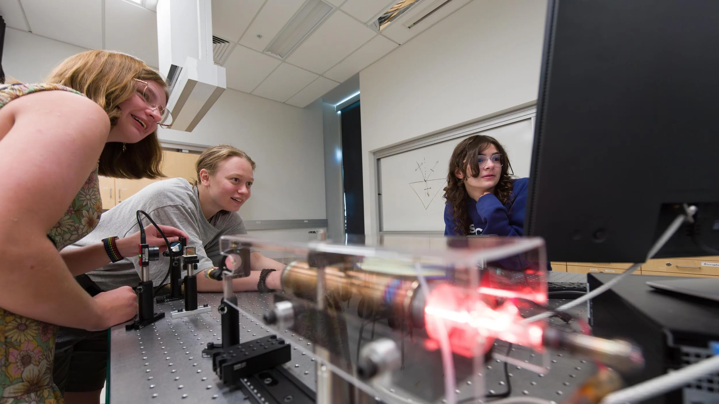 Mines students working with a computer and equipment in the Physics lab