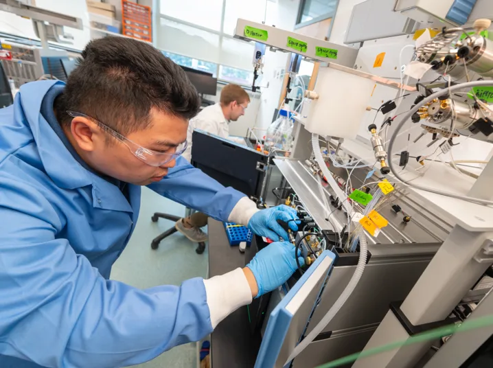 A researcher in a lab setting working with scientific machinery