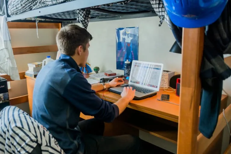 Mines student working on a laptop in a residence hall