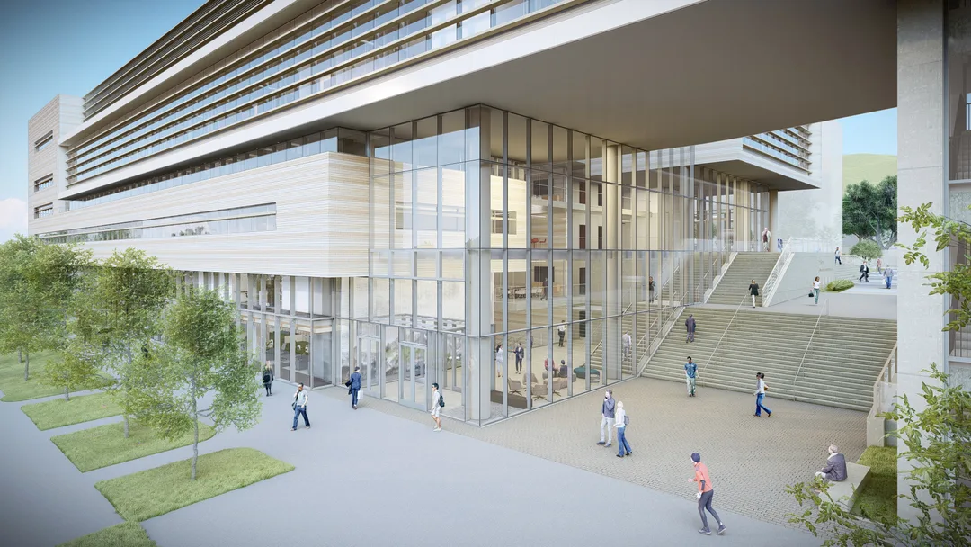 Modern building with large glass walls, outdoor stairs, people walking, and green trees along a paved walkway.