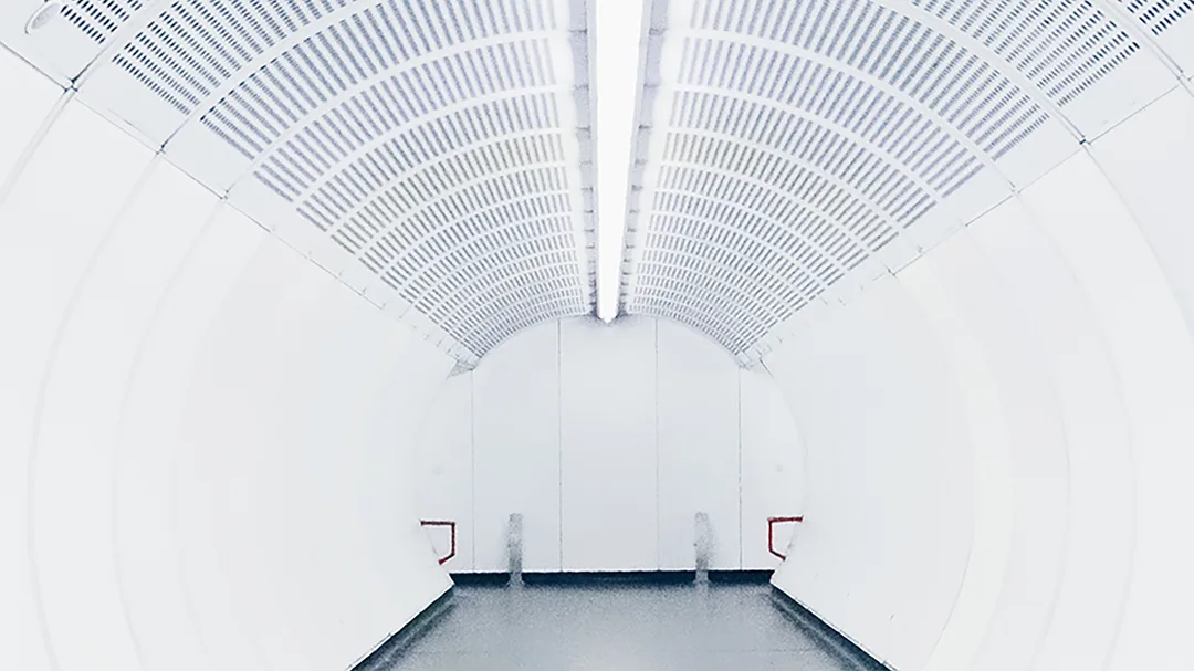 A long white tunnel with a light at the end.