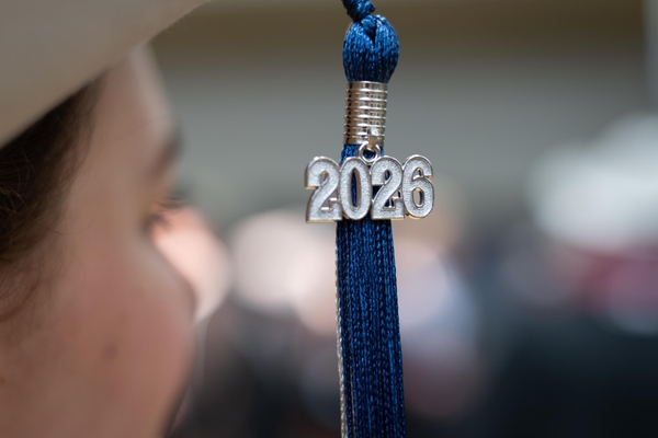 A close-up of a blue graduation tassel with a silver 2026 charm hangs near a graduate's cap at Colorado School of Mines Spring Commencement