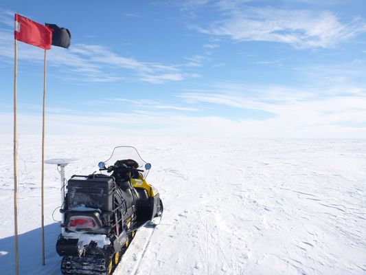 A snowmobile sits on Antarctic ice during geophysical research