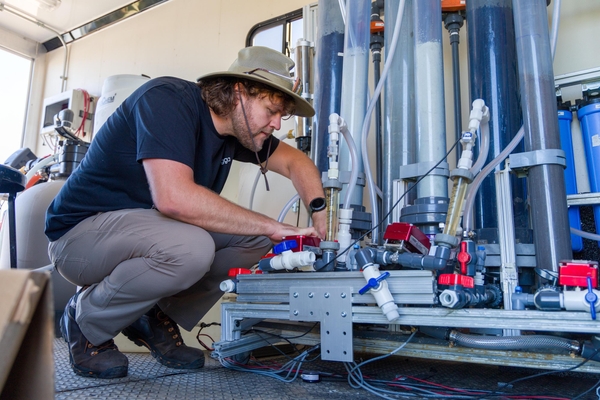 Researcher works on PFAS treatment system inside a trailer