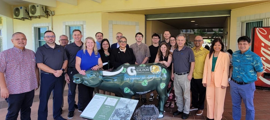 Group photo behind a statue on University of Guam campus