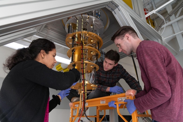 Director of the Quantum Engineering program works with two PhD students on a quantum dilution refrigerator