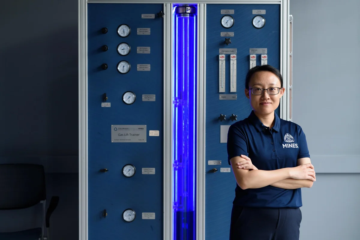Yilin Fan stands in front of equipment in a lab