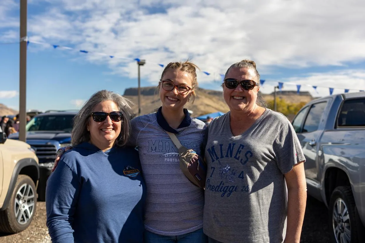 A Colorado School of Mines student stands with parents at the Family and Friends Weekend Tailgate.