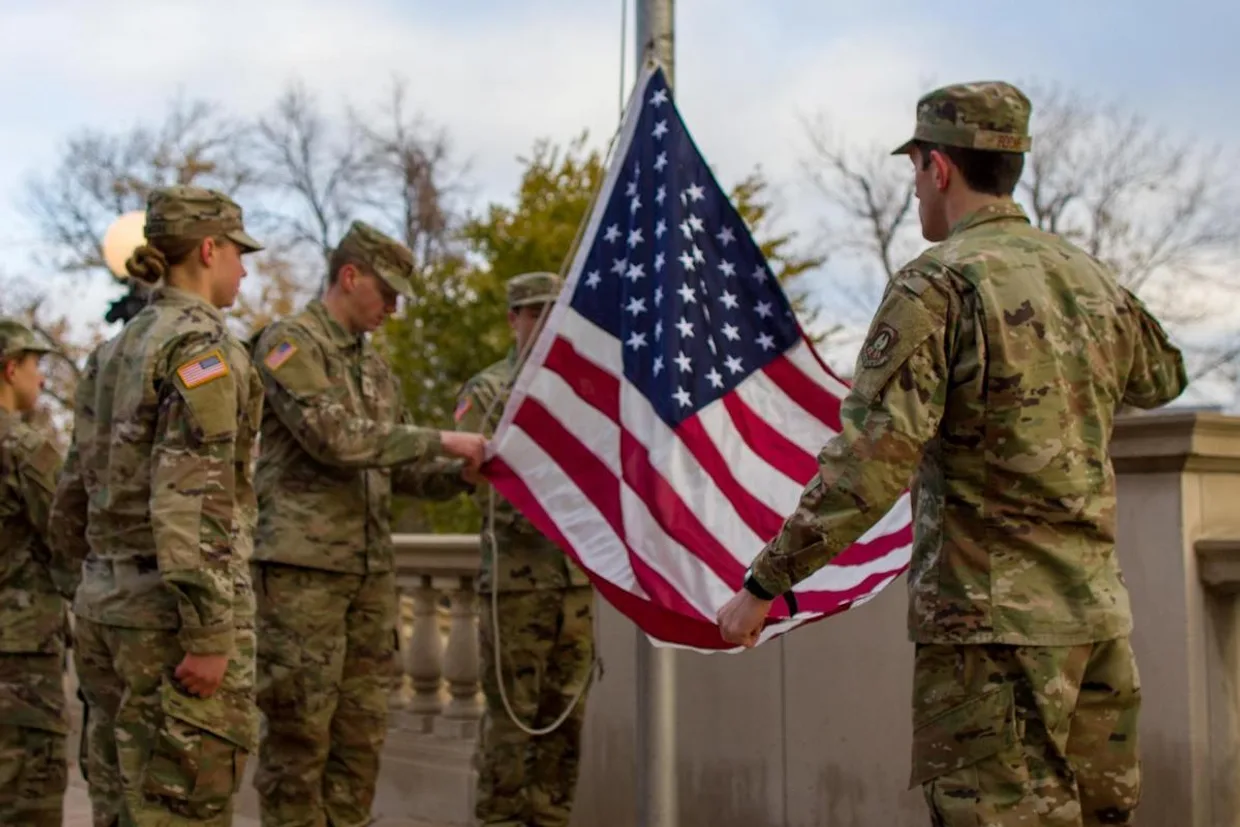Veterans and active duty students raise an American flag in honor of Veterans Day.