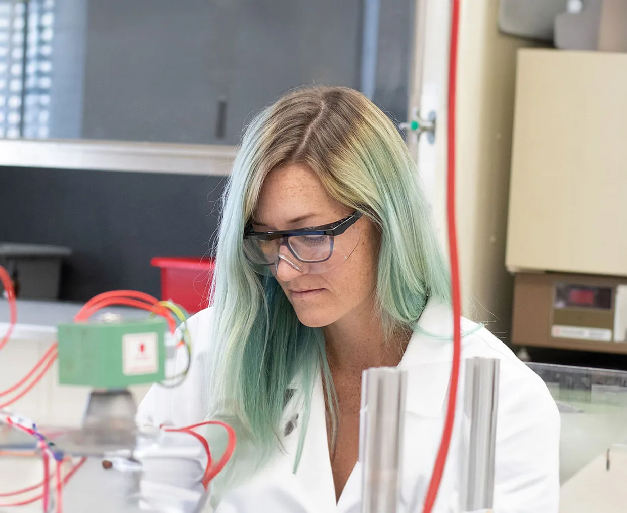 Grad student in a white lab coat performing experiments in the Nuclear Science and Engineering PhD Program.