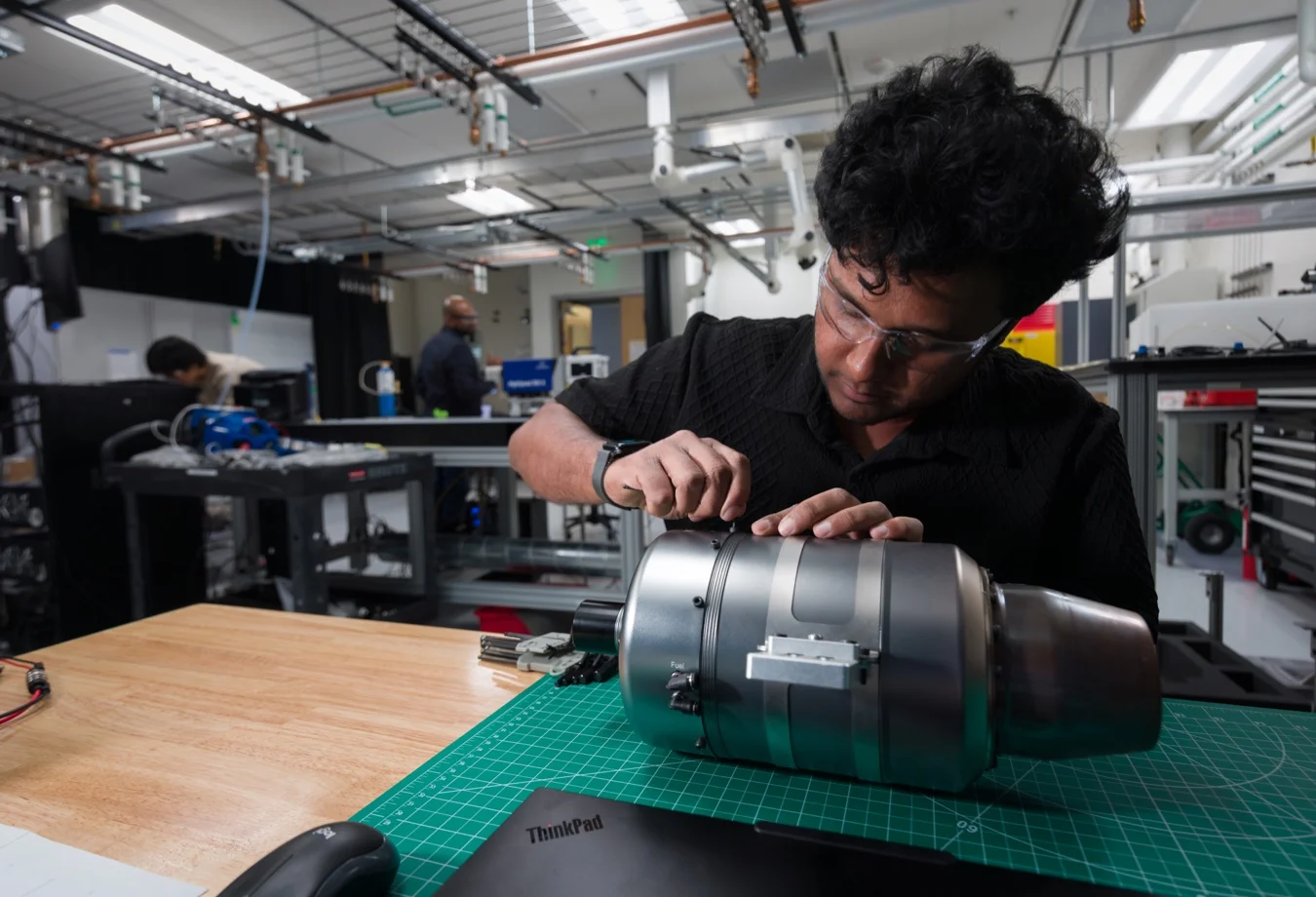 This image shows a person working on a small jet engine, which resembles a PBS TJ40 microturbine.
