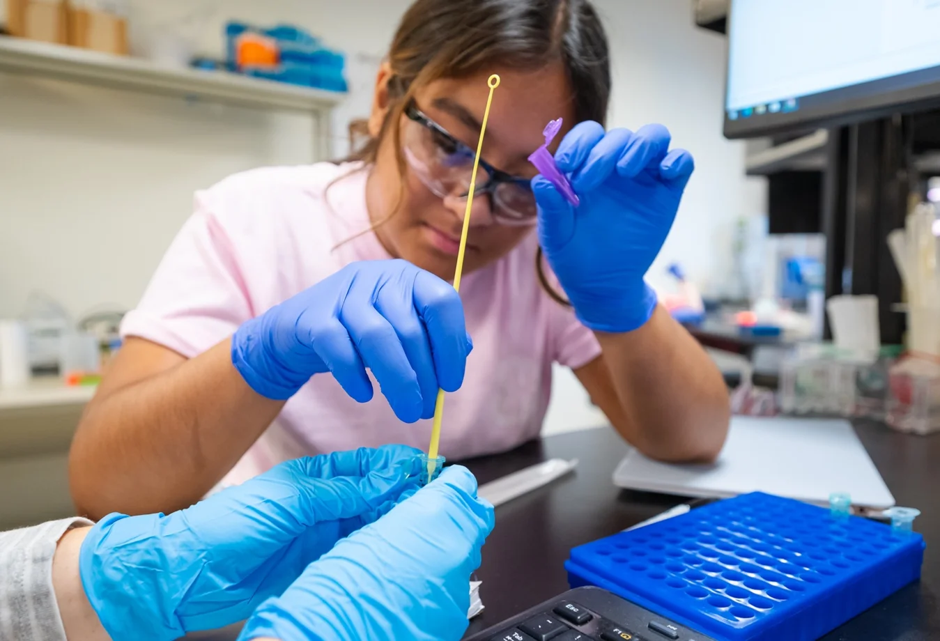 A female Mines student taking a test sample within the laboratory.