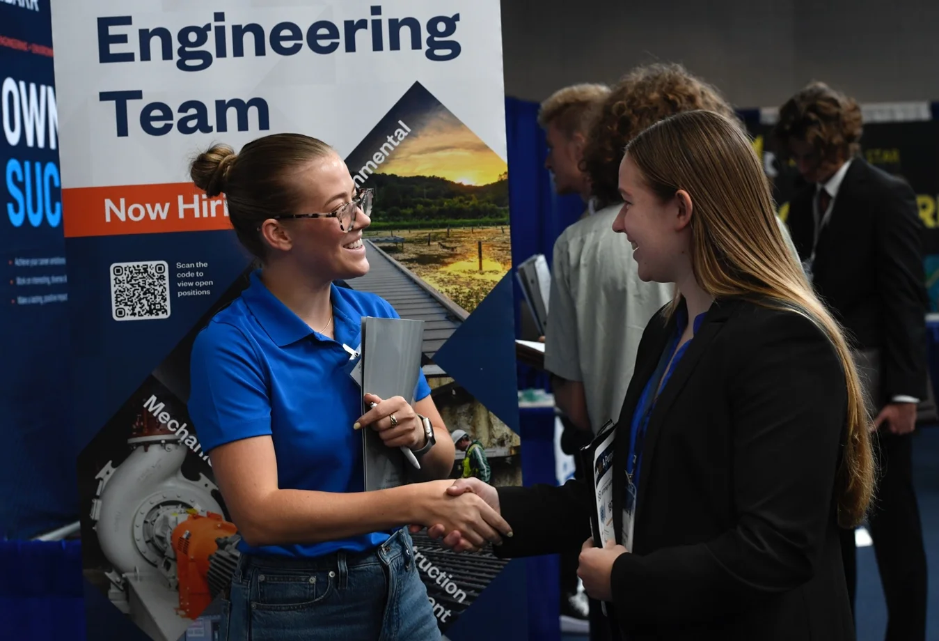 A female mines student attending a career fair and meeting with a recruiter.