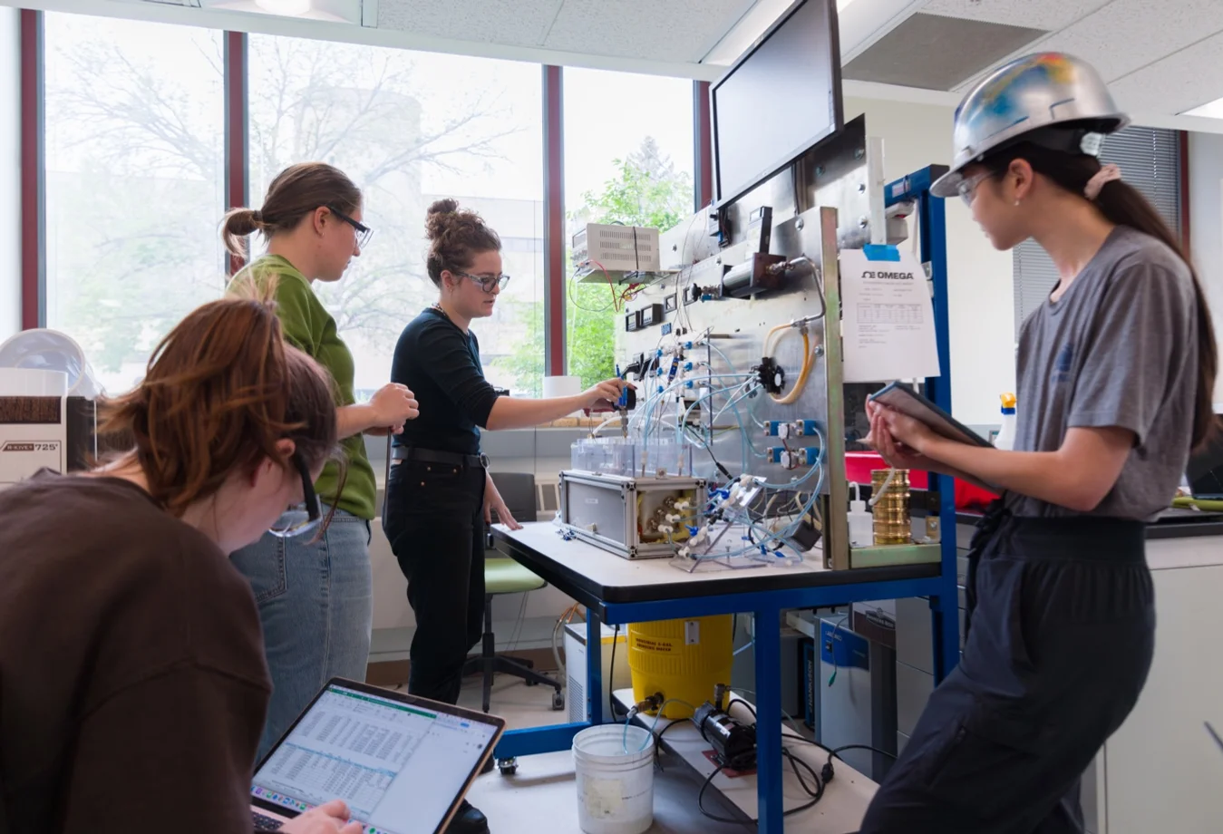 Female Mines students performing research and test results in a lab.