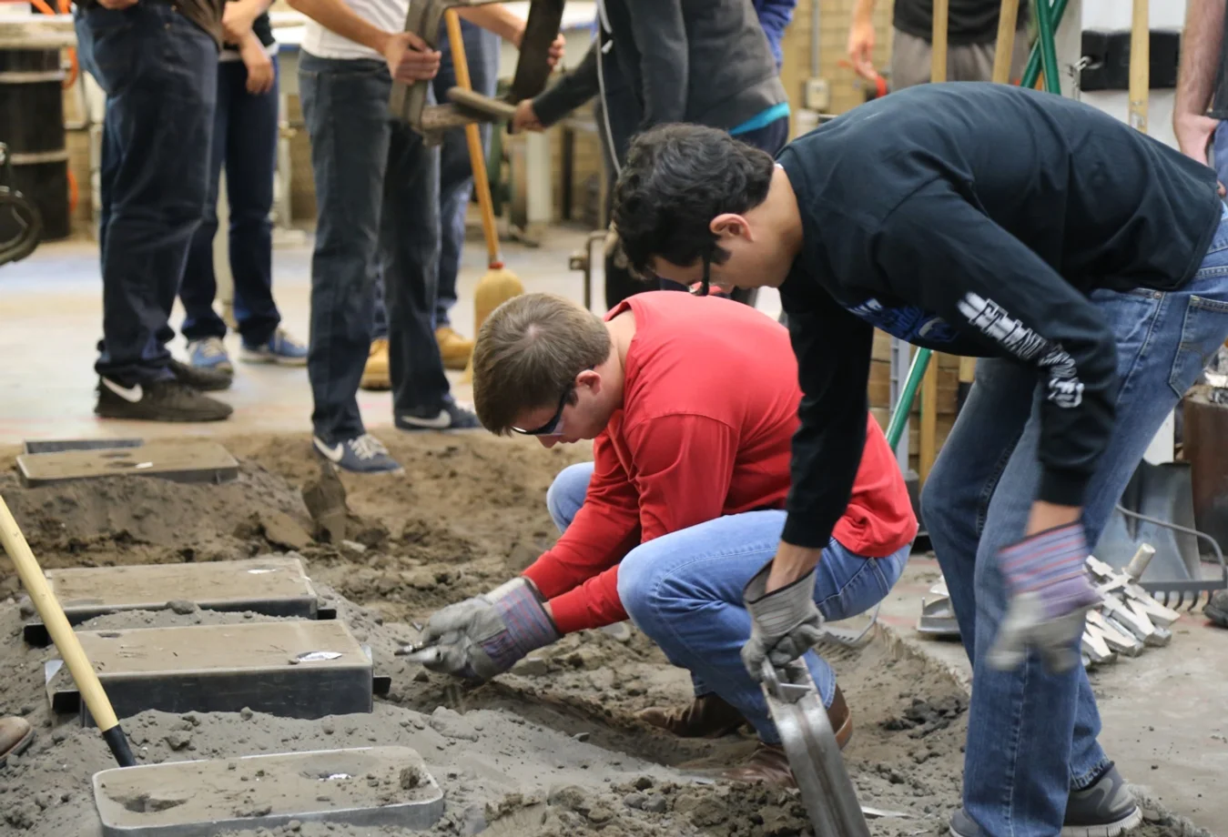 Mines students getting hands-on construction training, practicing pouring and leveling mortar