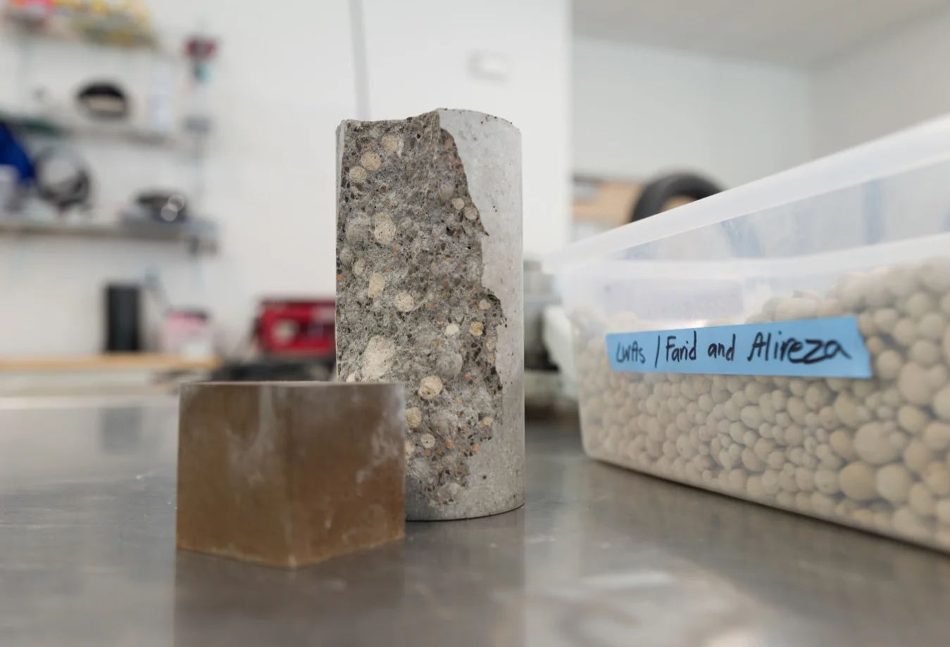 A concrete specimen and laboratory materials in side a lab workspace.