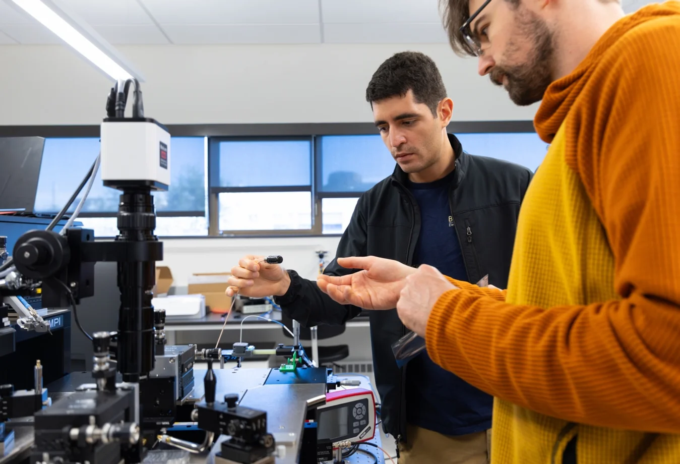 Mines researcher using a visible laser to align a microwave photonic chip as part of a quantum engineering progra