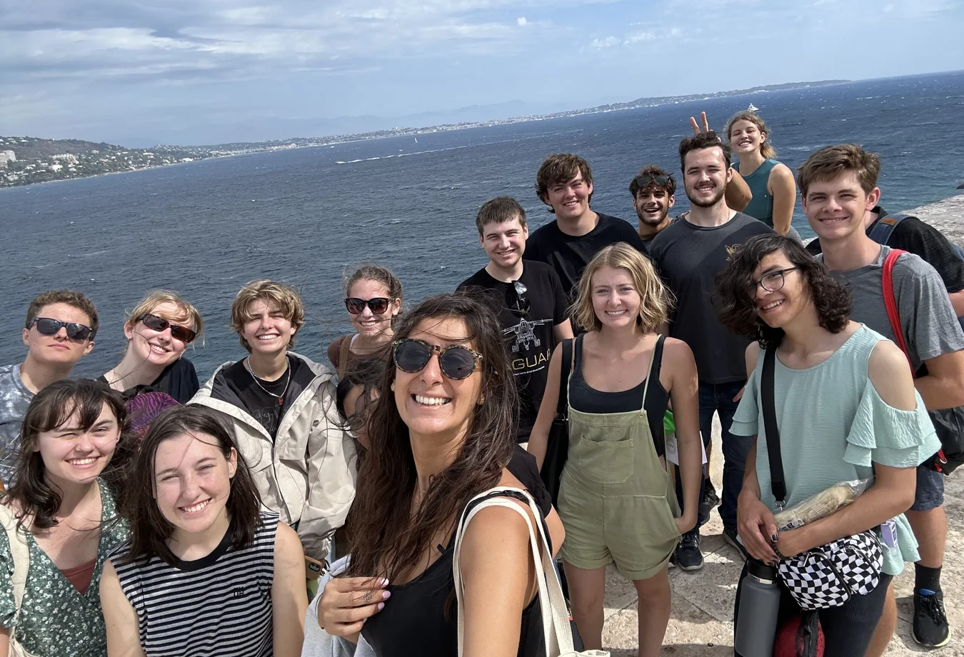 A group of students posing in Sainte-Marguerite during a study abroad excursion with the ocean in the background