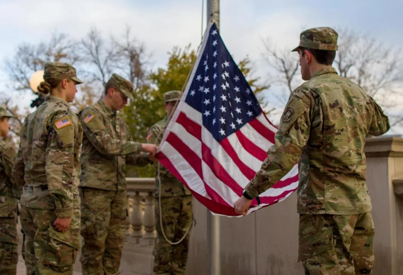 Veterans and active duty students raise an American flag in honor of Veterans Day.