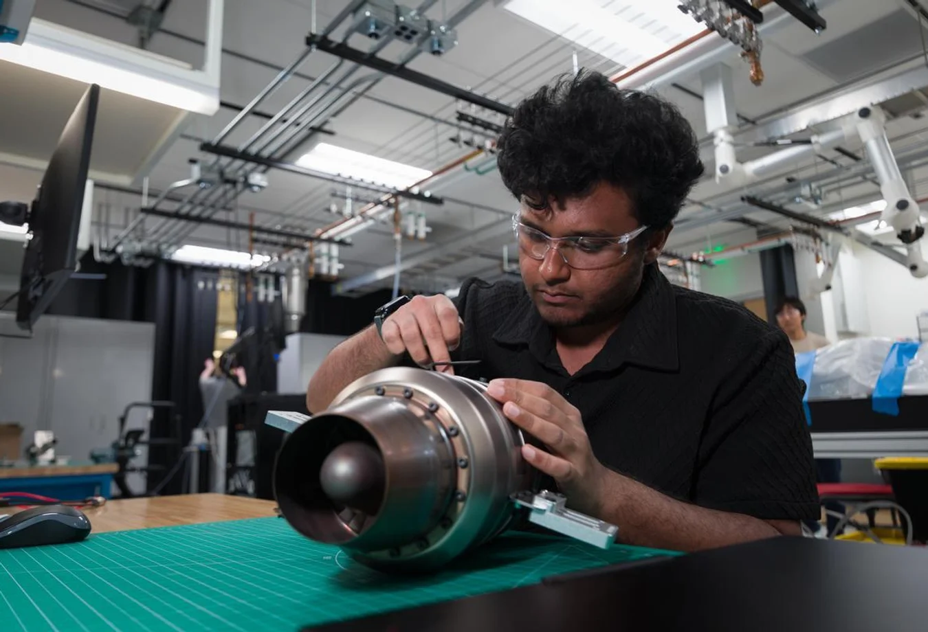 A Mines grad student builds a propulsion engine in a diagnostics lab.