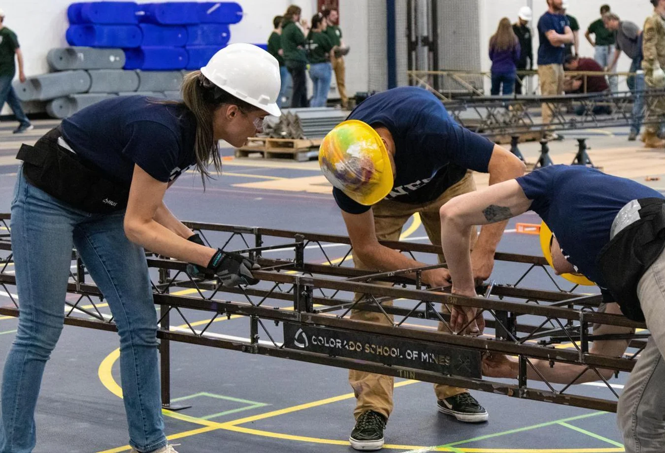 A team of three Mines students construct a miniature metal bridge as part of the ASCE Regional Bridge Building Competition.
