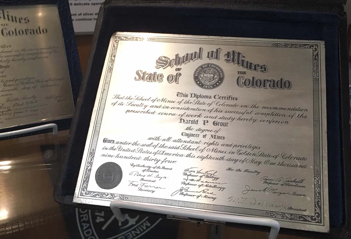 Diploma from the Colorado School of Mines awarded to Harold P. Grout for Engineer of Mines degree in 1934, displayed in a protective case.