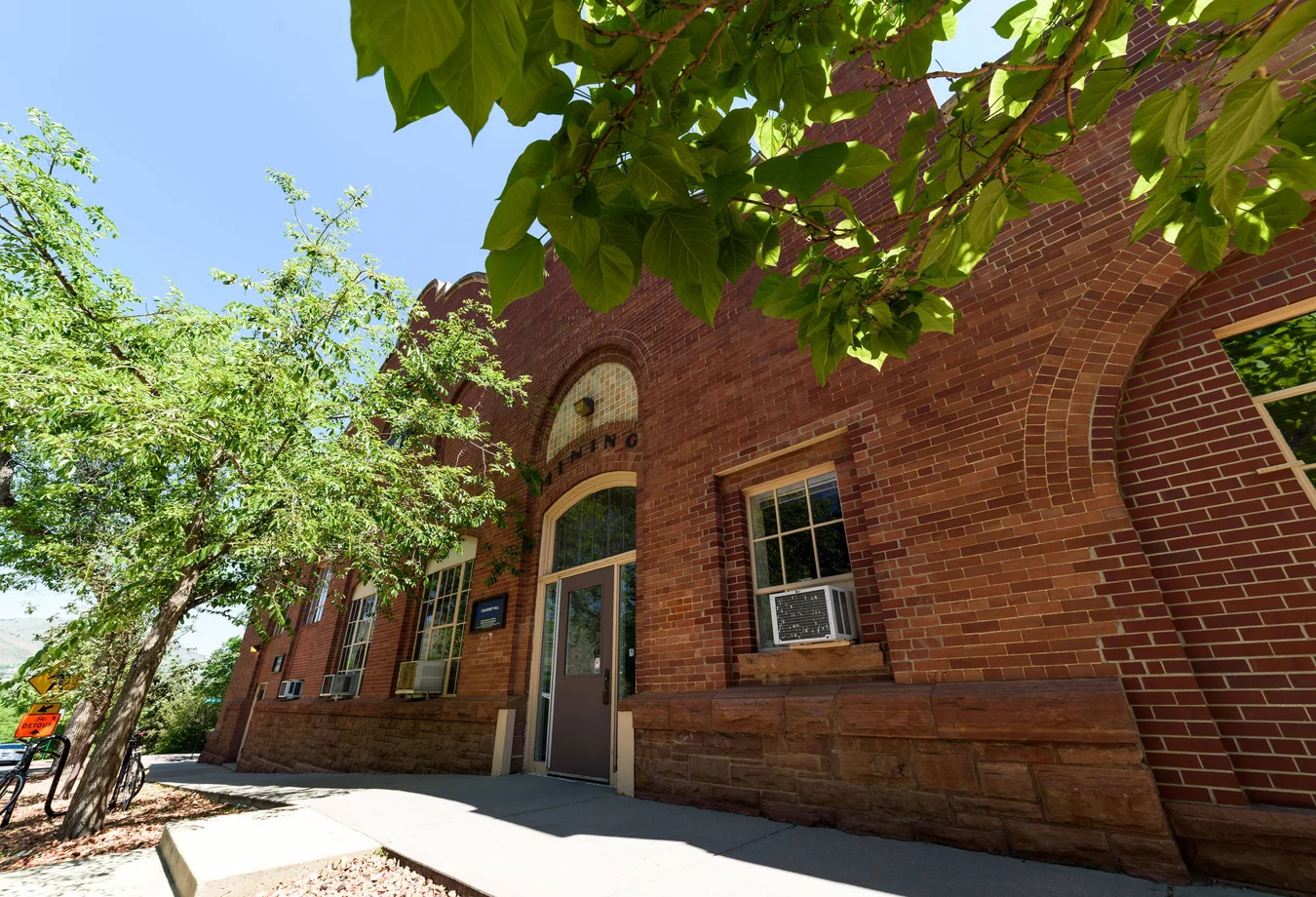 A brick building with a tree in front of it.