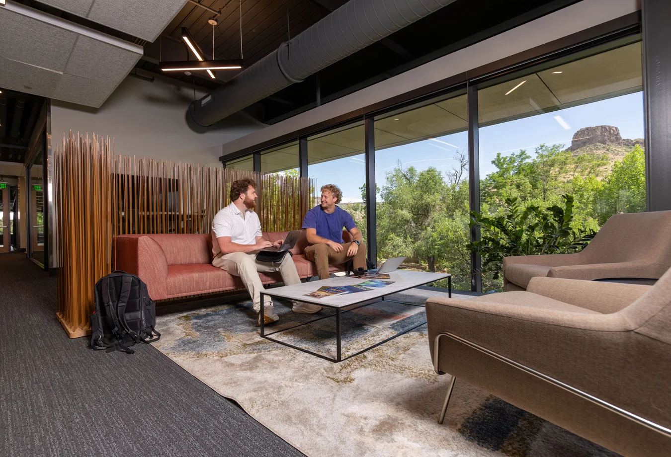 A couple of men sitting on a couch in a room.