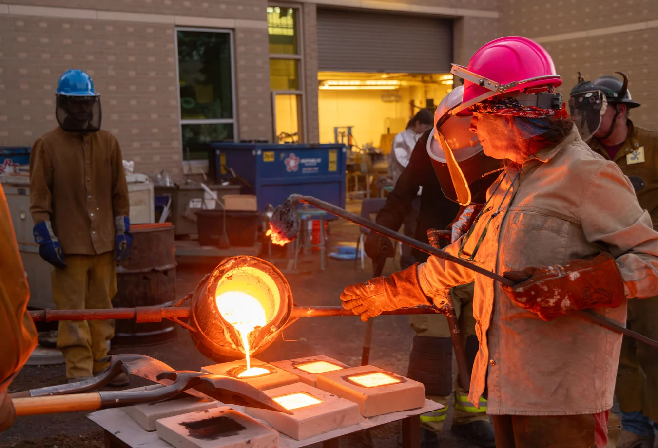 A group of men in hard hats and hard hats working on a piece of metal.