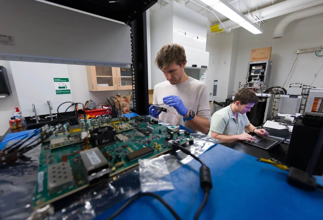 Two men working on a computer motherboard in a lab.