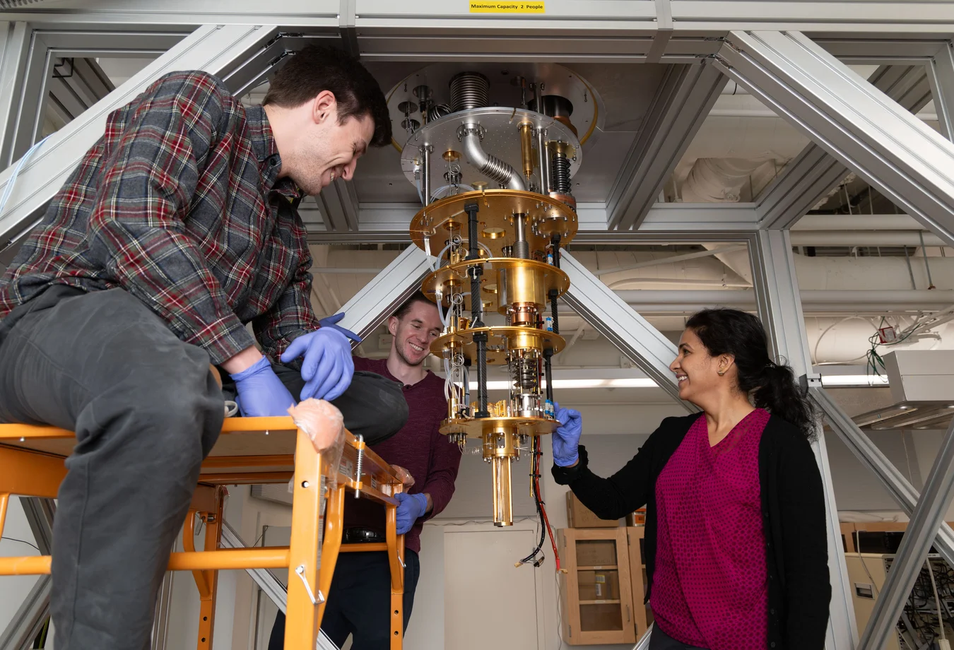 A group of people standing around a machine in a room.