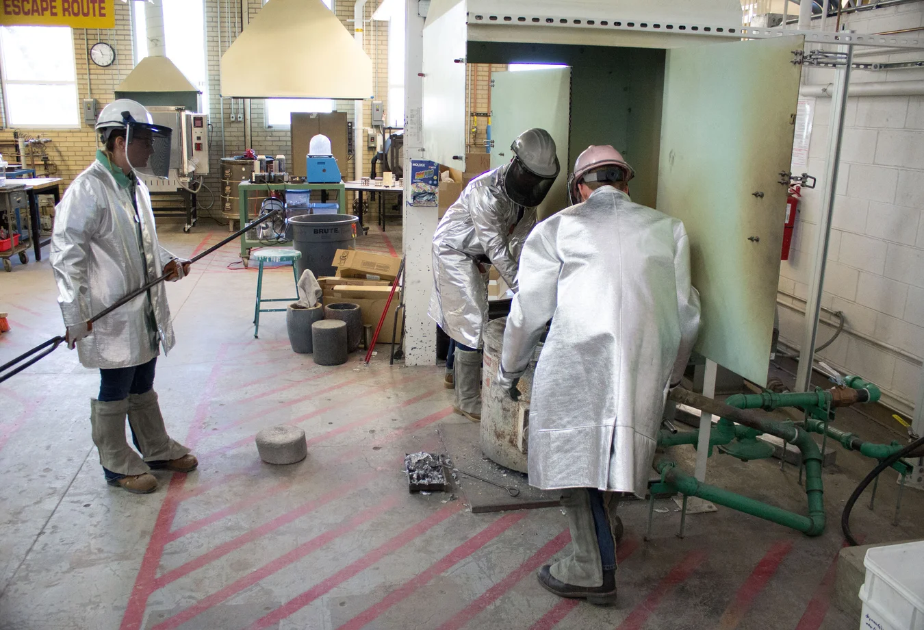 A group of men in protective gear working in a factory.
