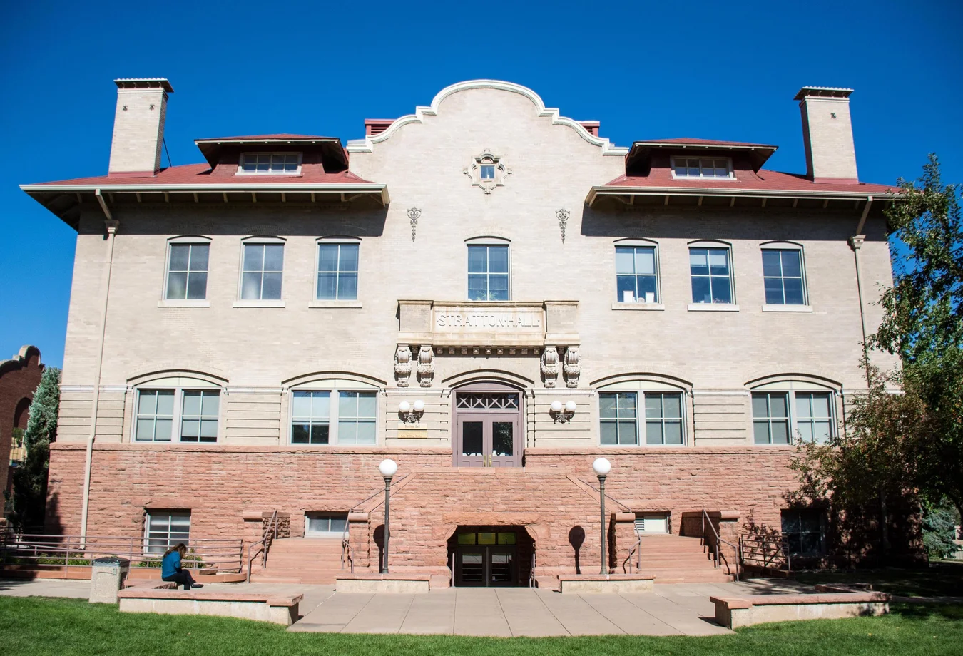 A large building featuring a prominent red roof, showcasing its architectural design and surrounding landscape.