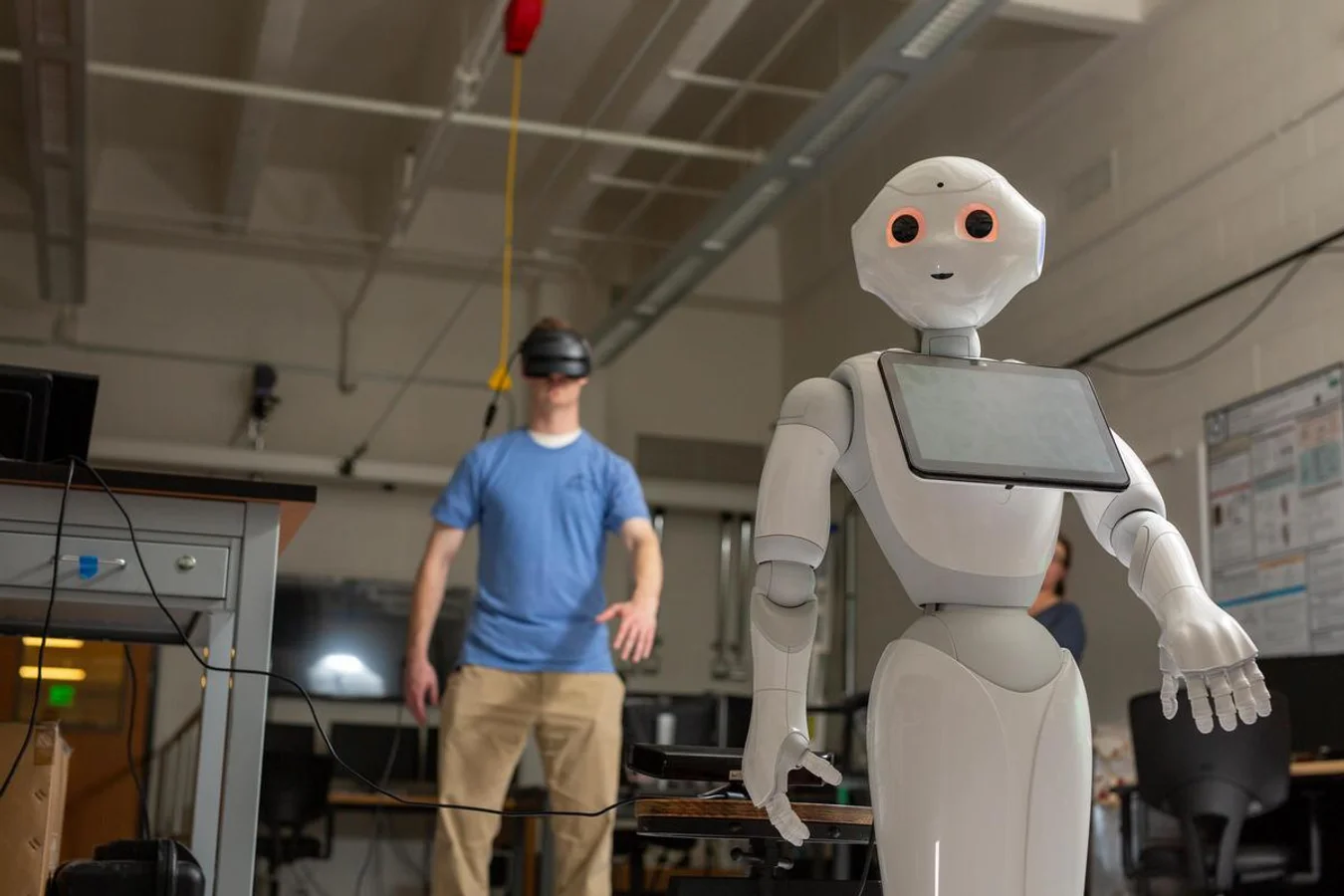 Mines student operating a humanoid robot remotely with VR goggles.