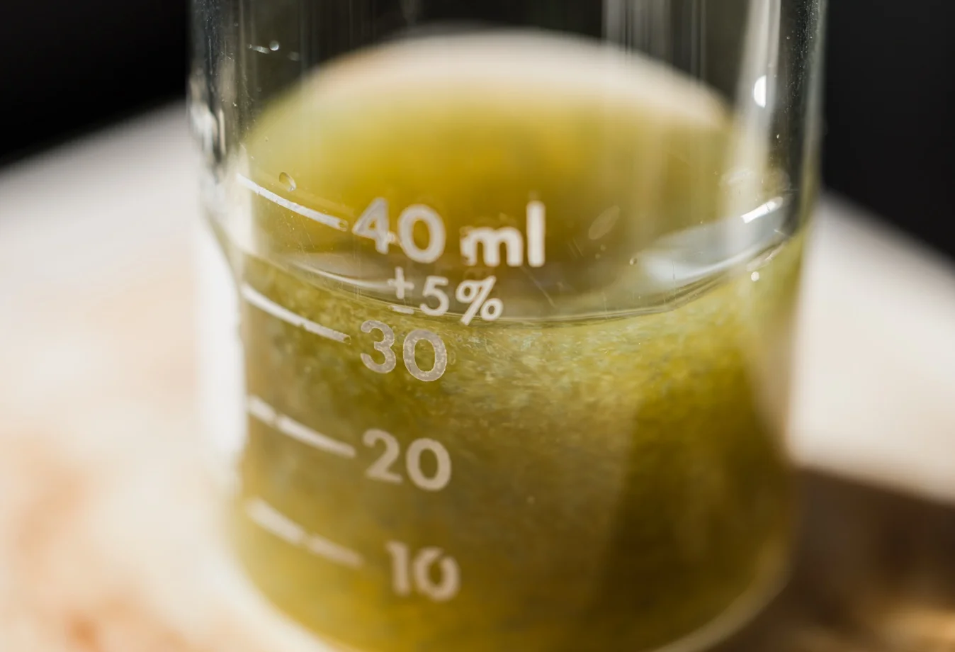 a closeup of green liquids contained in a laboratory beaker