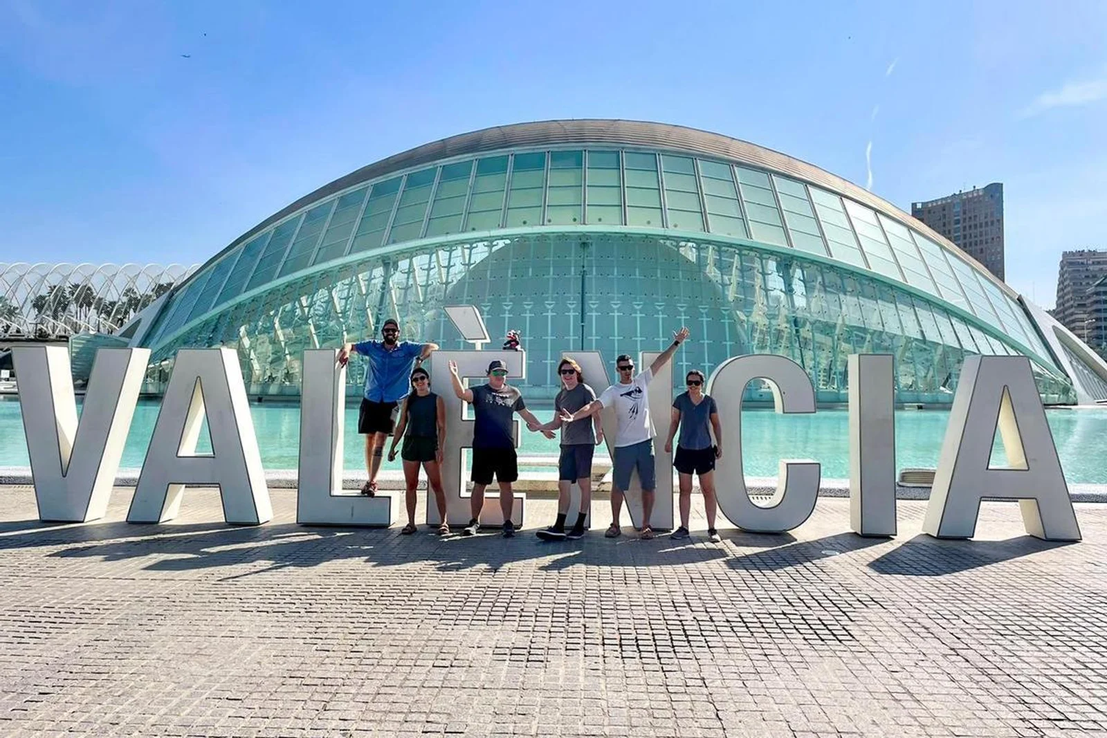 Group of seven students posing behind large 