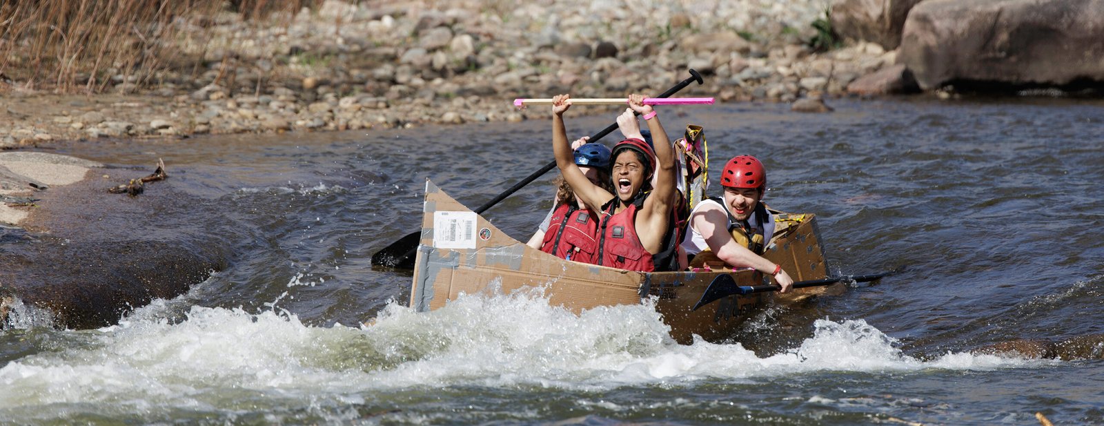Mines students riding a cardboard boat at E-Days