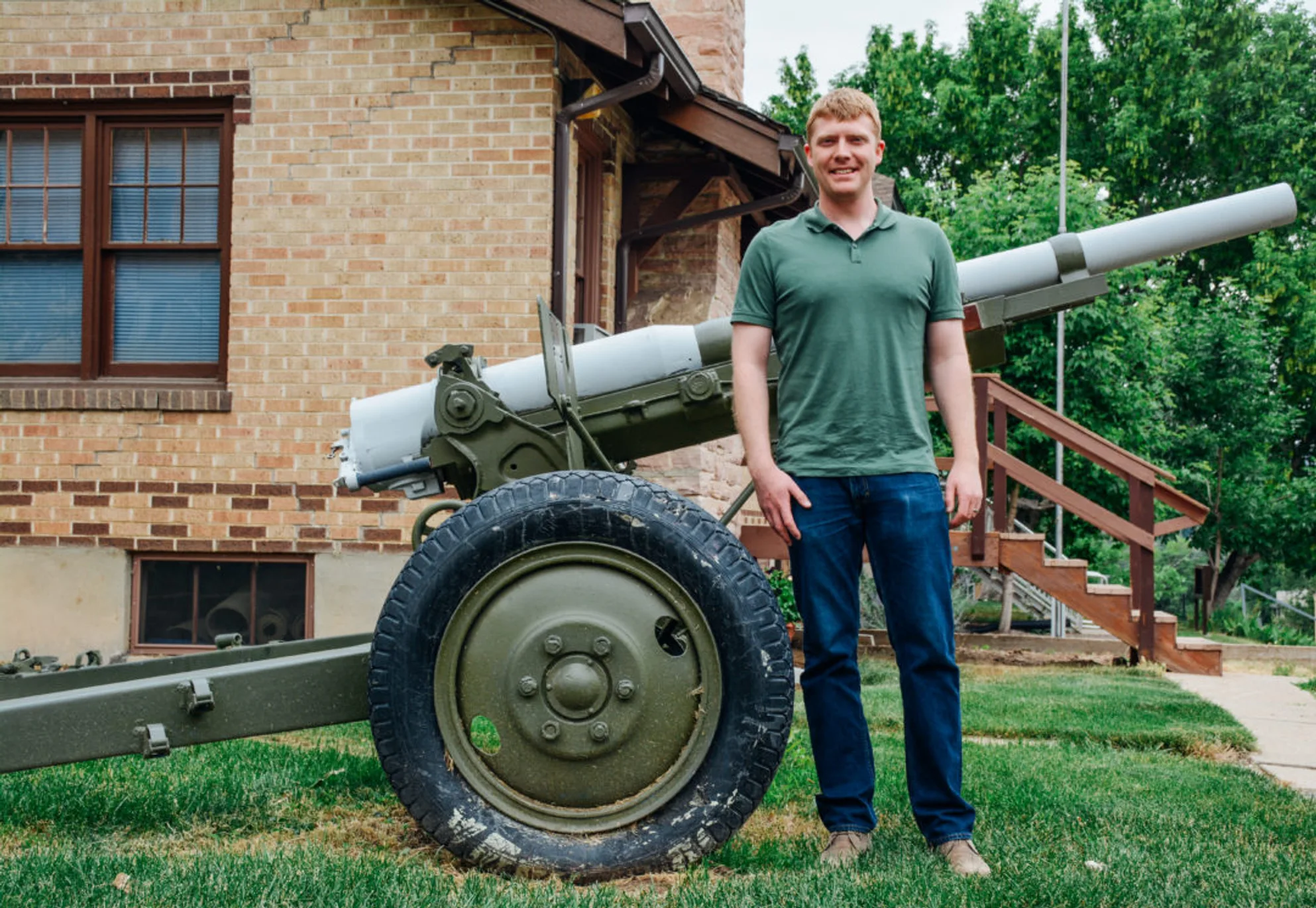 Mines ROTC alumnus Joe Geiger, '09, stands next to a World War II anti-tank cannon.