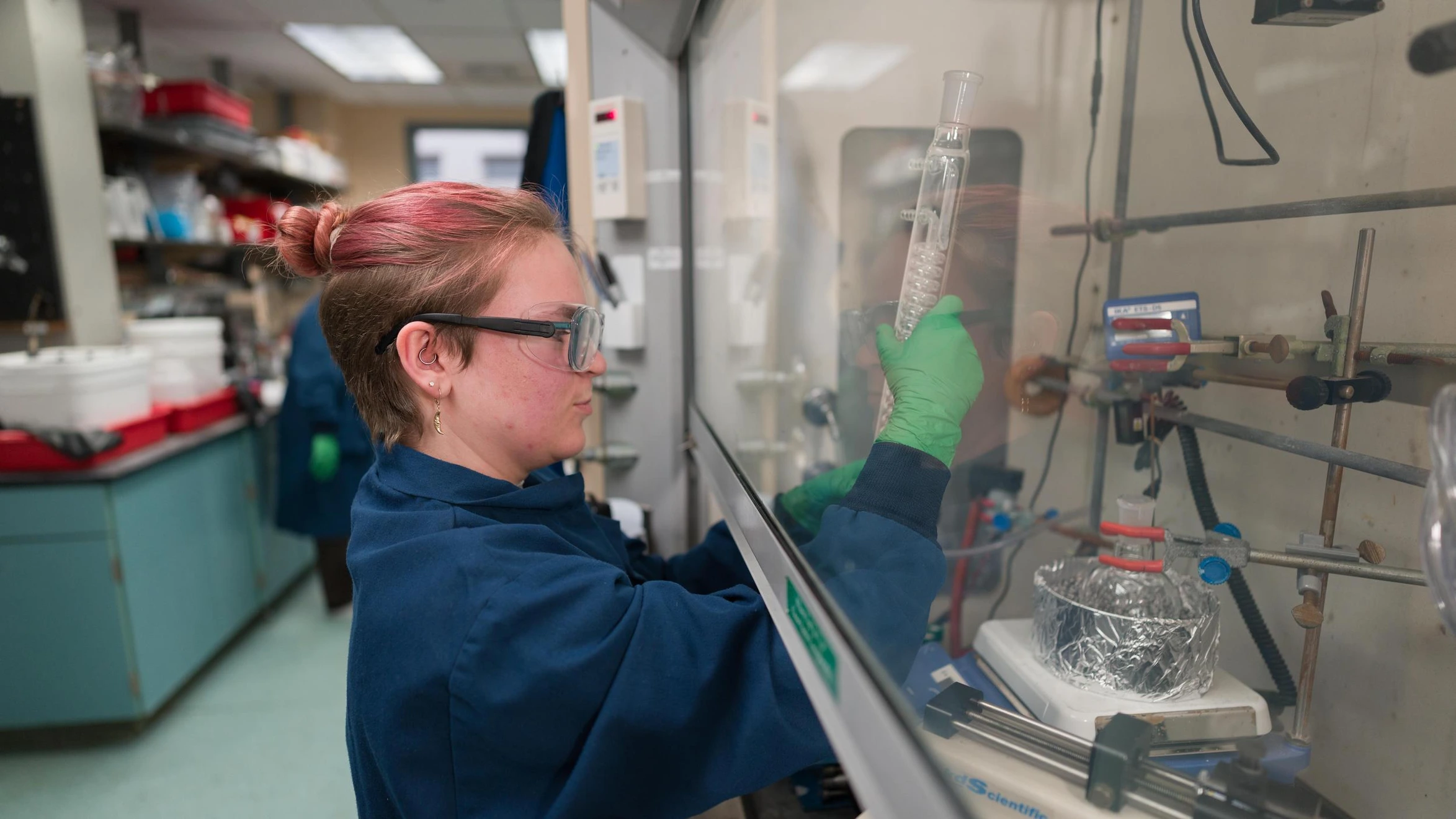 Sarah Thorson (Undergraduate, Chemical & Biological Engineering) setting up a reflux column in the McGuirk Lab.