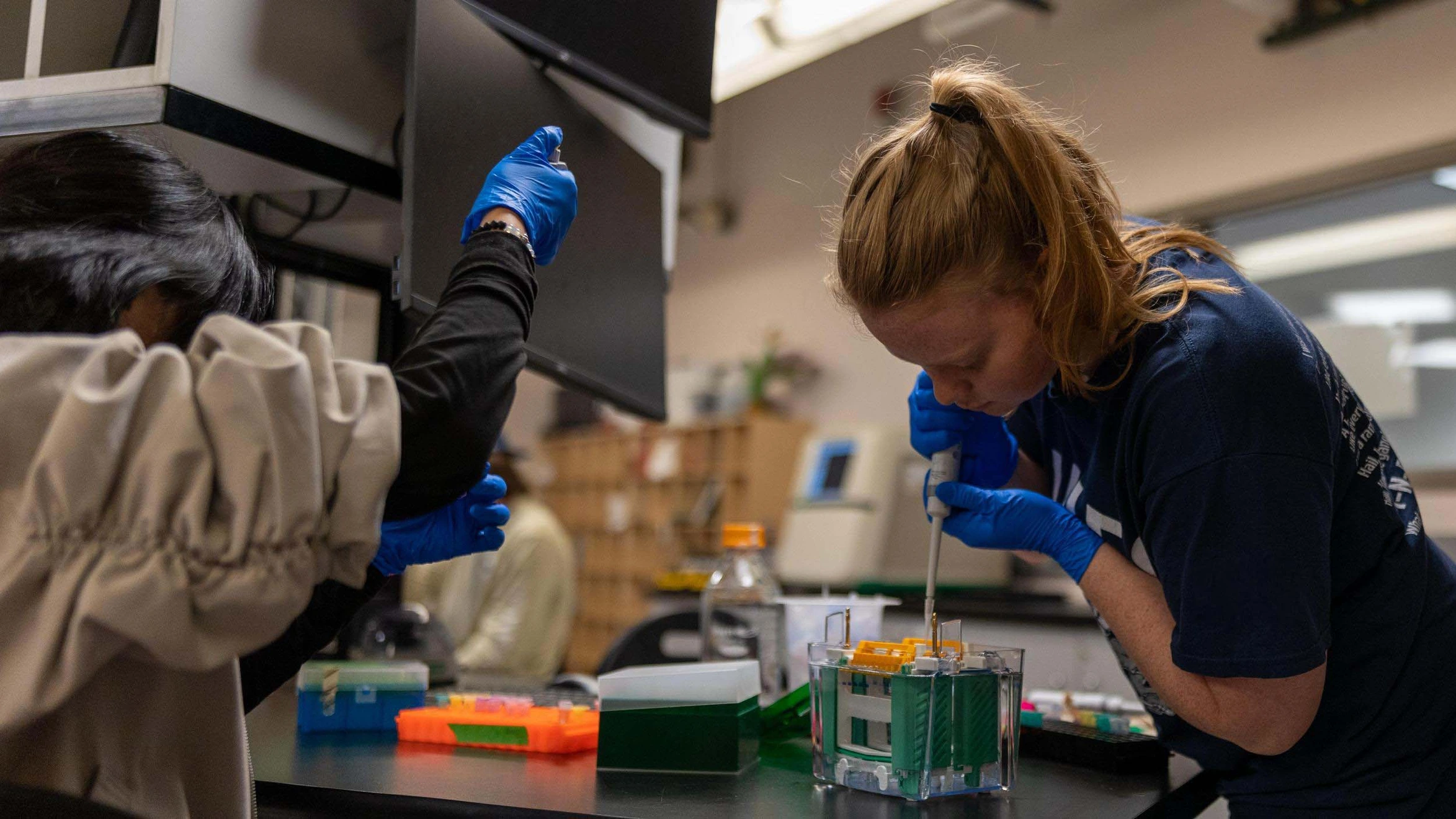 A Mines QBE graduate student uses a syringe to measure out liquid in bioscience laboratory.
