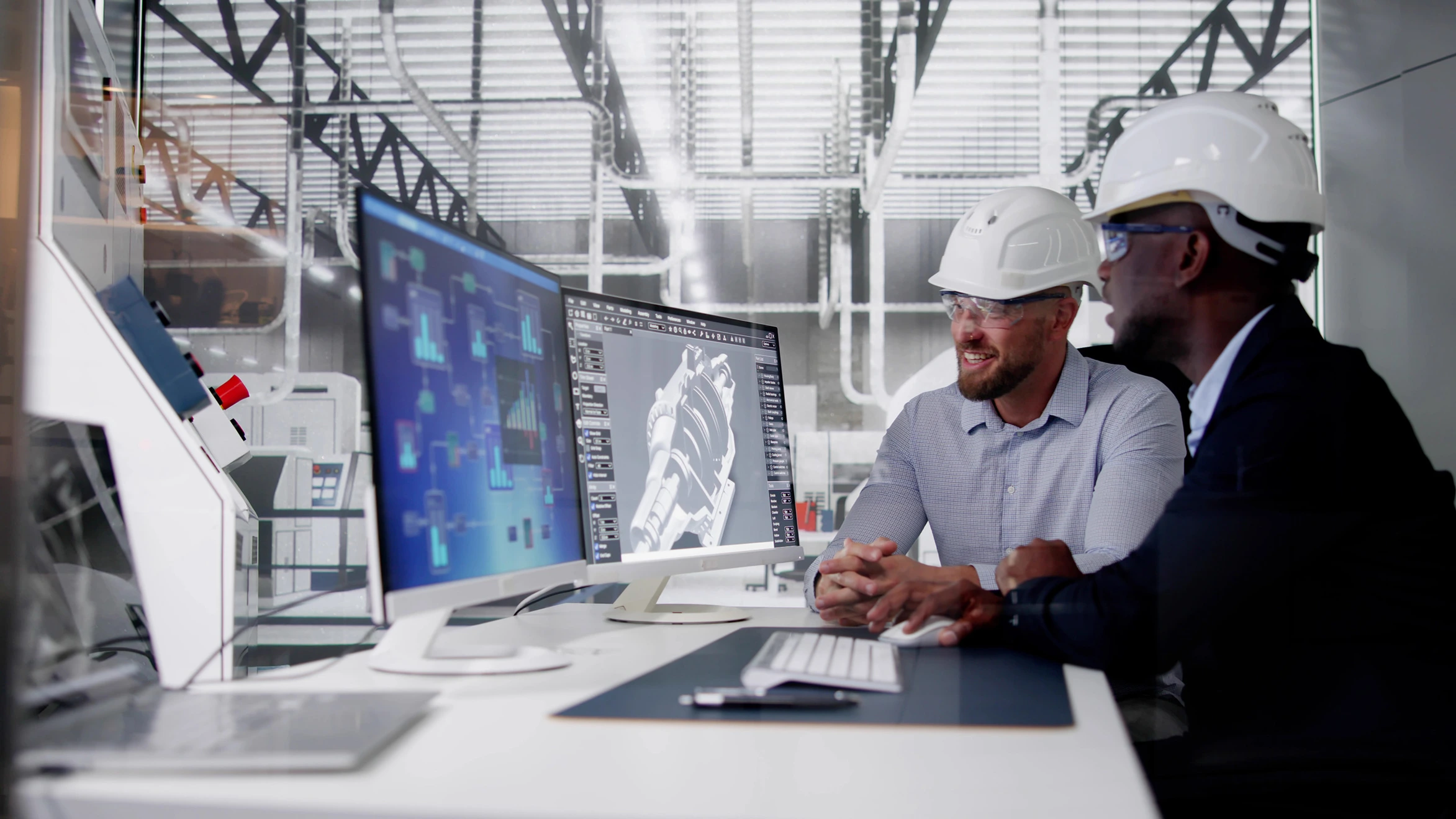 Two men in hard hats looking at a computer screen.