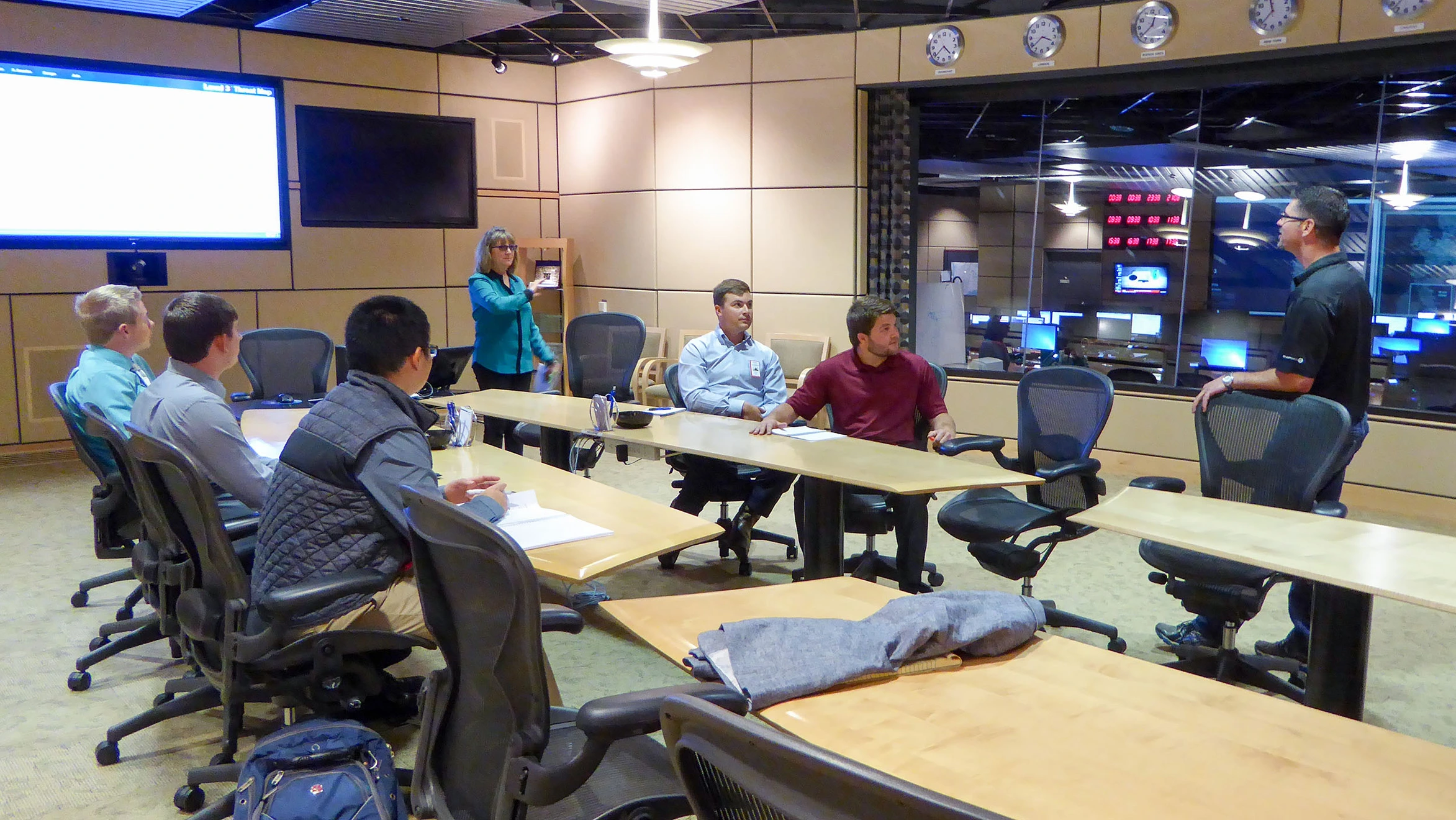 A group of people sitting around a long table in a room.