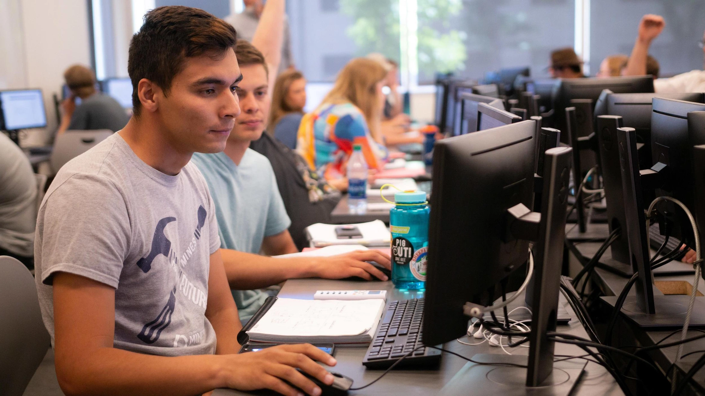 A group of people sitting at computers in a classroom.