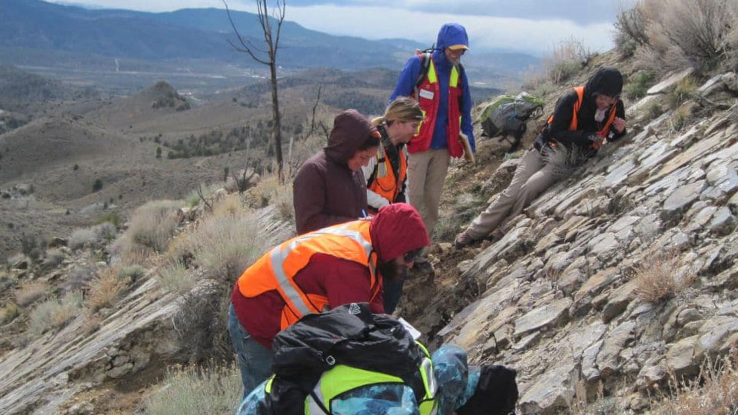 A group of people standing on top of a rocky hillside.