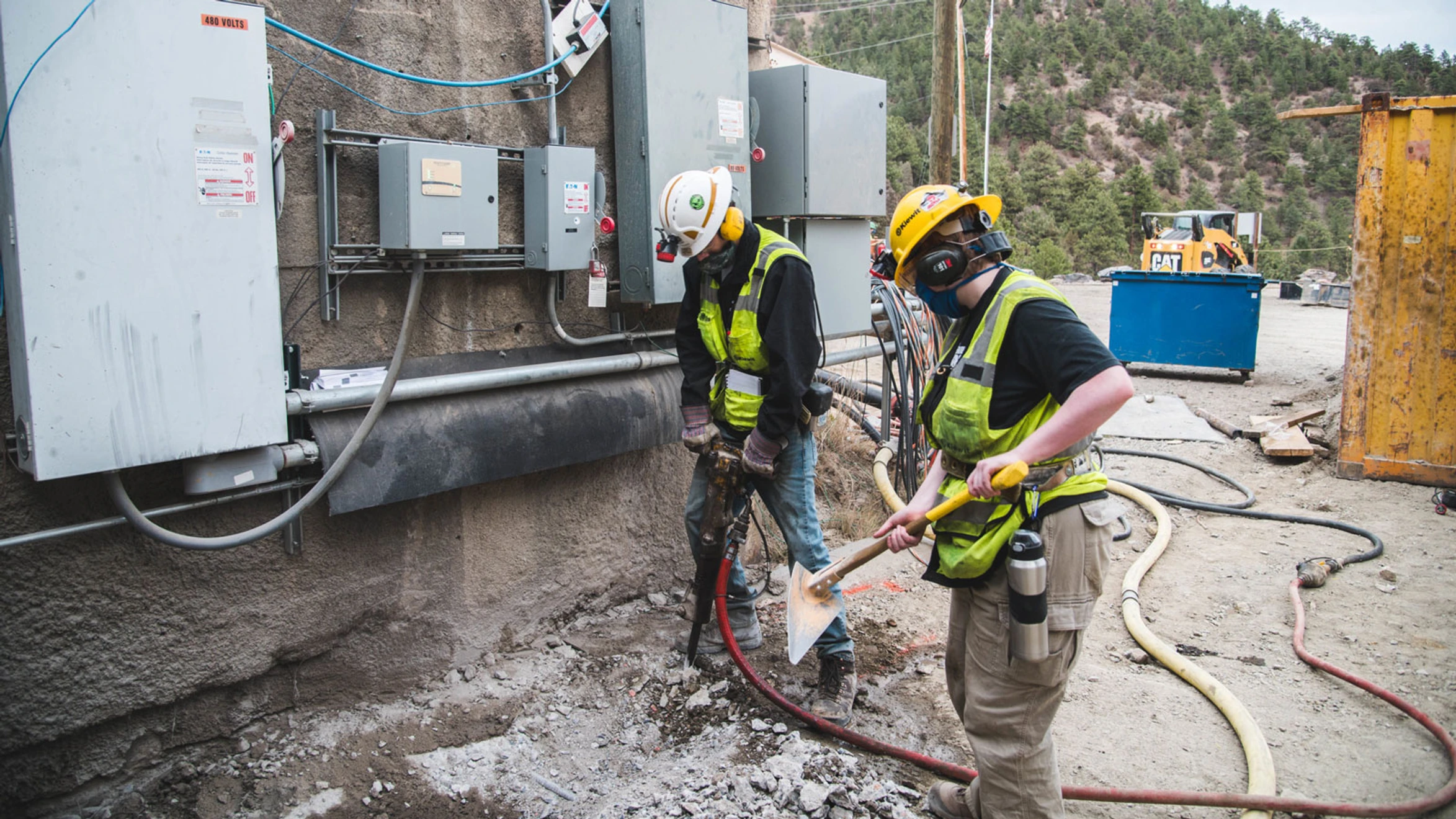 A group of men in hard hats and safety vests working on a construction site.