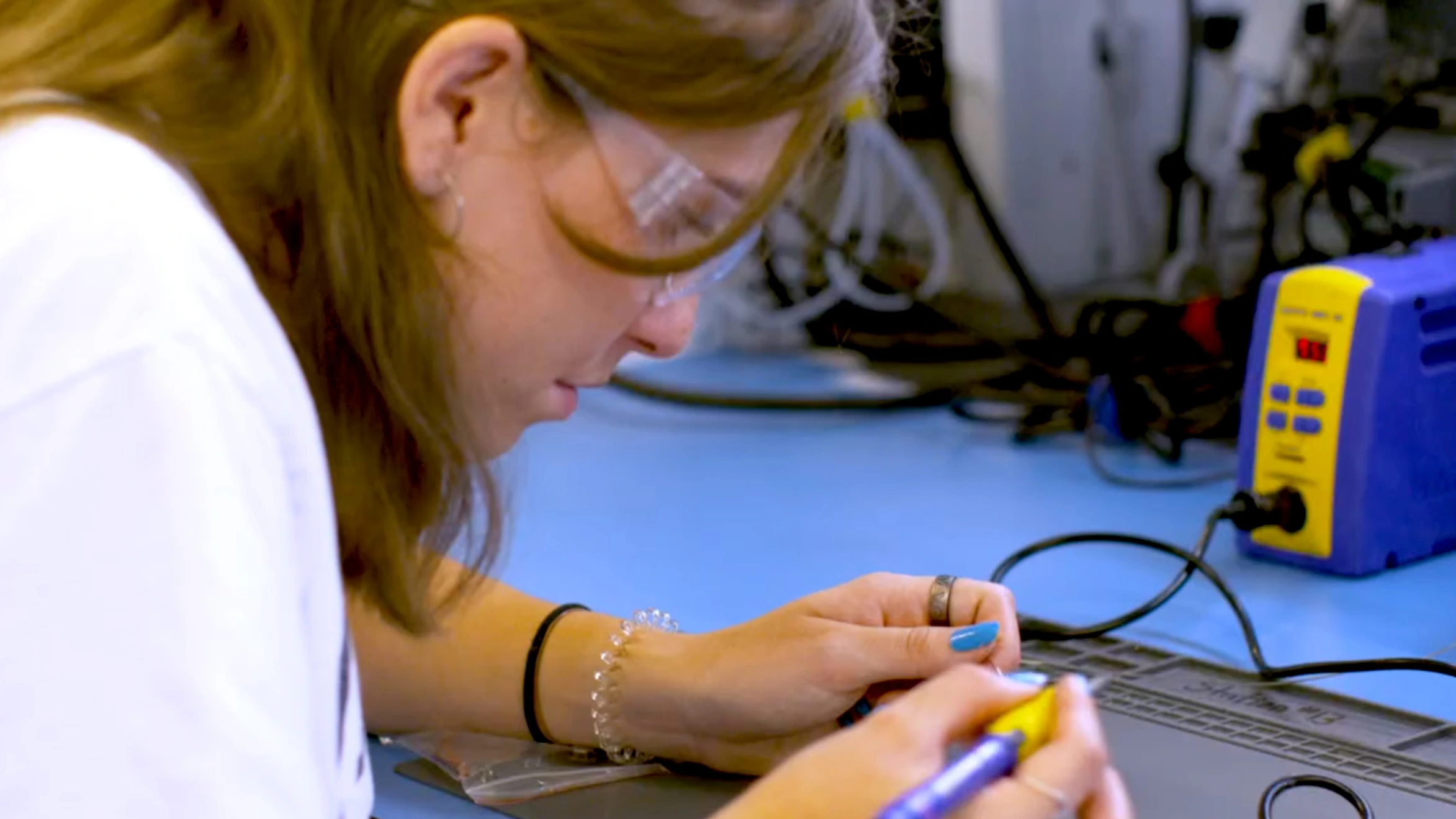 A woman in a lab coat working on a computer.